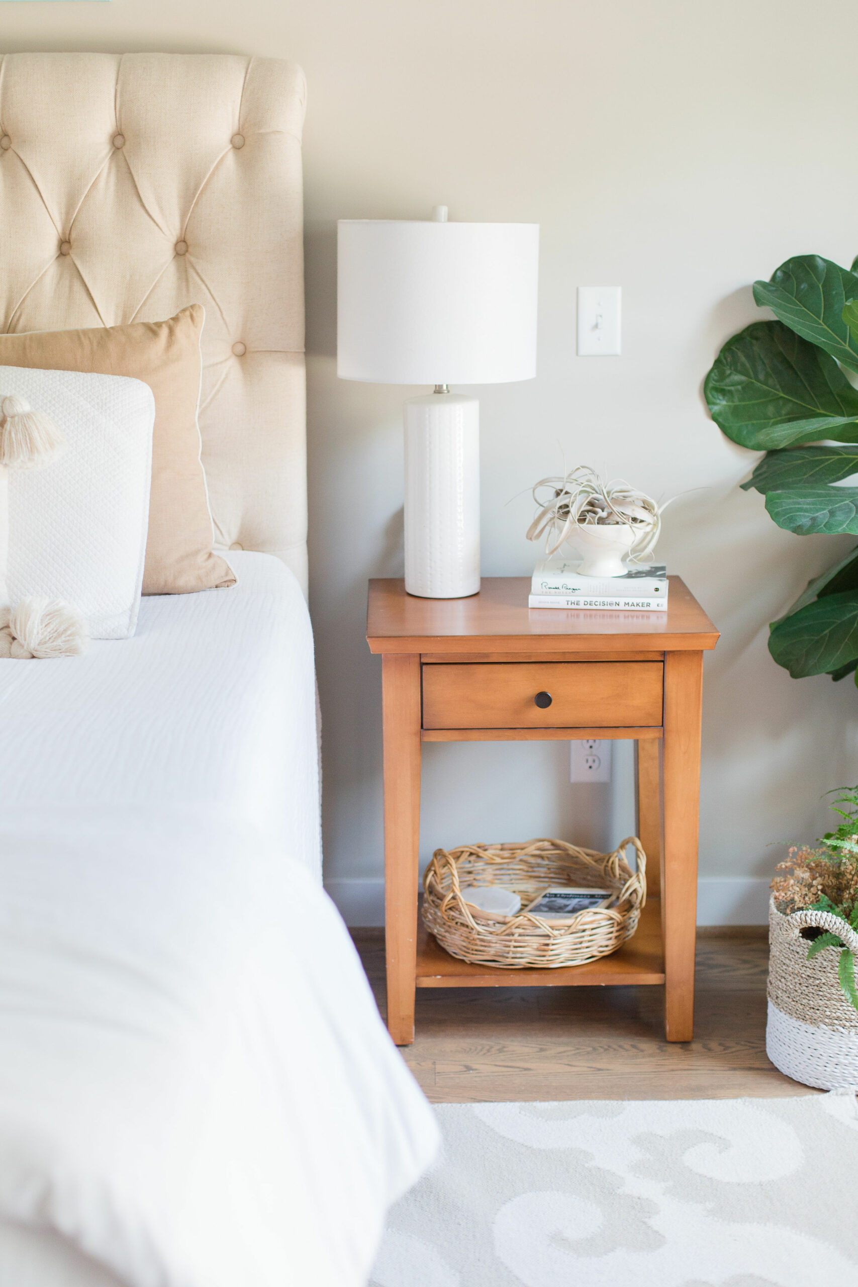 Bed, nightstand with lamp, houseplants