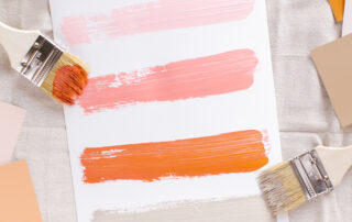 paint brushes with five stripes of multicolored paint on a sheet of paper