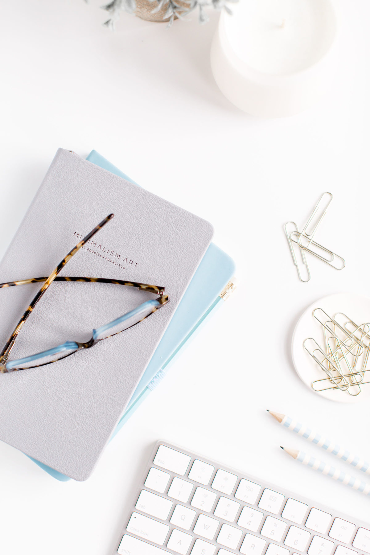 Desktop with books, glasses, paperclips, keyboard